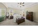 Bright bedroom boasts a tray ceiling, ensuite bathroom, and a dark wooden dresser at 129 Camille Cir, Youngsville, NC 27596