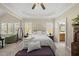 A bright main bedroom boasts a tray ceiling, plush carpet, and an ensuite bathroom at 129 Camille Cir, Youngsville, NC 27596