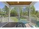 Inviting screened porch with wood ceiling, classic railing, and views of the green backyard and mature trees at 129 Camille Cir, Youngsville, NC 27596