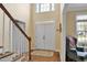 Bright foyer with hardwood floors, a staircase, and a view of the front door with transom window at 1335 Saint Andrews Dr, Mebane, NC 27302