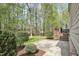 Stone patio and lush greenery connect to the home's wooden deck at 1335 Saint Andrews Dr, Mebane, NC 27302