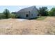 Spacious backyard shows home's exterior, a patio area, and newly laid straw at 1394 Delma Grimes Rd, Coats, NC 27521