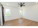 Bright bedroom featuring hardwood floors, ceiling fan, and two windows at 1394 Delma Grimes Rd, Coats, NC 27521