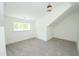 Sunny bedroom with neutral carpeting, large window, and unique sloped ceiling at 1394 Delma Grimes Rd, Coats, NC 27521