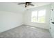 Well-lit bedroom features soft carpeting, a ceiling fan, and a large window at 1394 Delma Grimes Rd, Coats, NC 27521