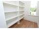 White closet shelving with a window and light hardwood flooring at 1394 Delma Grimes Rd, Coats, NC 27521