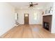 Bright living room featuring hardwood floors, brick fireplace, and ceiling fan at 1394 Delma Grimes Rd, Coats, NC 27521