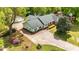 Aerial view of a well maintained property with lush greenery, long driveway, and brick and green exterior at 1410 Cross Link Rd, Raleigh, NC 27610