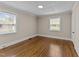 View of the bedroom with hardwood floors, two windows, and fresh paint at 1410 Cross Link Rd, Raleigh, NC 27610