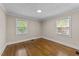 Bedroom with wood floors, fresh paint, and two large windows at 1410 Cross Link Rd, Raleigh, NC 27610