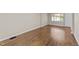 Empty bedroom with hardwood floors, fresh paint, and a window overlooking the yard at 1410 Cross Link Rd, Raleigh, NC 27610