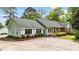 Charming single story home featuring brick and light green siding, complemented by a concrete driveway at 1410 Cross Link Rd, Raleigh, NC 27610