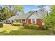 Cozy single story home showcasing a brick facade and light green siding, with neatly trimmed landscaping at 1410 Cross Link Rd, Raleigh, NC 27610