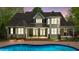 Expansive backyard featuring a private swimming pool, a covered porch with a swing, and lush landscaping at 144 W Walker Woods Ln, Clayton, NC 27527