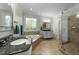 Bathroom with glass shower, soaker tub, double sinks, and decorative window at 144 W Walker Woods Ln, Clayton, NC 27527