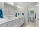 Bright bathroom featuring a double vanity, framed mirror, and separate water closet at 144 W Walker Woods Ln, Clayton, NC 27527