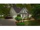 Charming two-story home with a well-manicured lawn, lush greenery, and a private driveway leading to an attached garage at 144 W Walker Woods Ln, Clayton, NC 27527