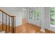 Bright foyer with hardwood floors, elegant staircase, and a glass-paneled front door, creating a grand entrance at 144 W Walker Woods Ln, Clayton, NC 27527