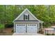 Two-car garage with painted siding, decorative trim, and black window shutters at 144 W Walker Woods Ln, Clayton, NC 27527