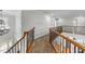 Open hallway with wood and black wrought iron railing and carpet flooring at 144 W Walker Woods Ln, Clayton, NC 27527