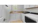 Bright laundry room with sink, cabinetry, and modern washer/dryer at 144 W Walker Woods Ln, Clayton, NC 27527