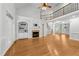 Open-concept living room with hardwood floors, a fireplace, built-in bookshelves, and an elegant staircase at 144 W Walker Woods Ln, Clayton, NC 27527
