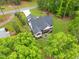 An aerial view of a house with a dark gray roof and surrounded by lush green trees at 1506 Gormly Cir, Sanford, NC 27330
