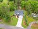 Aerial view of a beautiful home with lush landscaping, a long driveway, and a serene pond in the background at 1506 Gormly Cir, Sanford, NC 27330