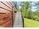 Backyard view of white-trimmed stairs leading to the lawn and trees at 1506 Gormly Cir, Sanford, NC 27330