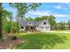 Inviting two-story farmhouse featuring mature trees, lawn with garden, and a three-car garage at 1506 Gormly Cir, Sanford, NC 27330