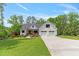 Beautiful two-story farmhouse boasts mature trees, manicured lawn and a three-car garage at 1506 Gormly Cir, Sanford, NC 27330