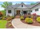 Charming two-story farmhouse featuring a landscaped front yard with a water feature at 1506 Gormly Cir, Sanford, NC 27330