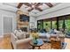 Spacious living room with a stone fireplace, beamed ceiling, and a covered patio visible through sliding glass doors at 1506 Gormly Cir, Sanford, NC 27330