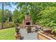 Relaxing outdoor fireplace area surrounded by greenery and a tranquil lake view at 1506 Gormly Cir, Sanford, NC 27330