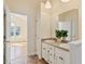 Bright bathroom featuring double vanity with large mirrors and natural light from a window at 1601 Entheos Ln, Raleigh, NC 27610