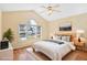 Staged primary bedroom with vaulted ceiling, ceiling fan, and view of the neighborhood at 1601 Entheos Ln, Raleigh, NC 27610