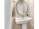 Chic powder room featuring a stylish pedestal sink and modern mirror at 1614 Brussels Drive Dr, Apex, NC 27502