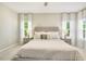 Bright bedroom featuring a king bed with an upholstered headboard and bedside tables with lamps at 1614 Brussels Drive Dr, Apex, NC 27502