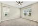 Bedroom featuring a ceiling fan, carpet, and two windows offering natural light and views at 1614 Brussels Drive Dr, Apex, NC 27502