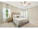 Bright bedroom featuring a king bed with an upholstered headboard, ceiling fan, and bedside tables with lamps at 1614 Brussels Drive Dr, Apex, NC 27502