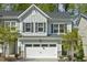 Charming townhouse with a two-car garage and light blue siding offers modern curb appeal at 1614 Brussels Drive Dr, Apex, NC 27502