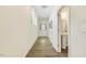 Hallway with wood floors, white walls, and view of the bathroom and door at 1614 Brussels Drive Dr, Apex, NC 27502