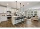 Open-concept kitchen featuring white cabinets, stainless steel appliances, and an island with bar stools at 1614 Brussels Drive Dr, Apex, NC 27502