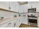 Well-lit kitchen featuring white cabinets, stainless steel appliances, and a subway tile backsplash at 1614 Brussels Drive Dr, Apex, NC 27502