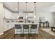 Bright kitchen with white cabinets, stainless steel appliances, and an island with seating for three at 1614 Brussels Drive Dr, Apex, NC 27502