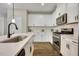 Modern kitchen featuring stainless steel appliances, white cabinets, and an island with a sink at 1614 Brussels Drive Dr, Apex, NC 27502
