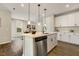 Open kitchen with a center island, stainless appliances, and seamless flow to the dining area at 1614 Brussels Drive Dr, Apex, NC 27502