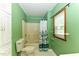Green bathroom with a shower/tub combo and a window at 1744 Prince Edward Dr, Elon, NC 27244