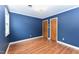 Blue bedroom showcasing wood floors and two doors at 1744 Prince Edward Dr, Elon, NC 27244
