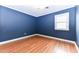 Blue bedroom featuring wood floors and a window at 1744 Prince Edward Dr, Elon, NC 27244